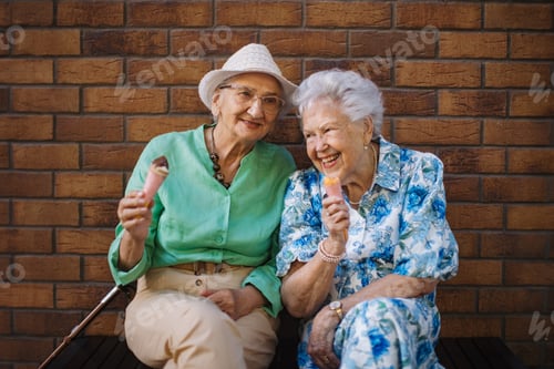 Preview: Portrait of two senior female friends in the city, eating ice cream on a hot summer day.
