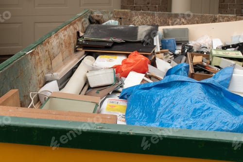Preview: Skip bin full of household waste rubbish on the front yard. House clean up