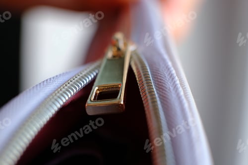 Preview: Selective focus, yellow metal zipper of a makeup bag or small purse macro pattern background