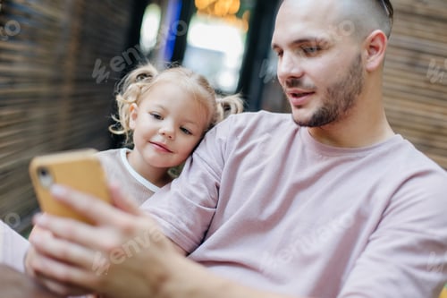 Preview: Father and daughter looking at smartphone