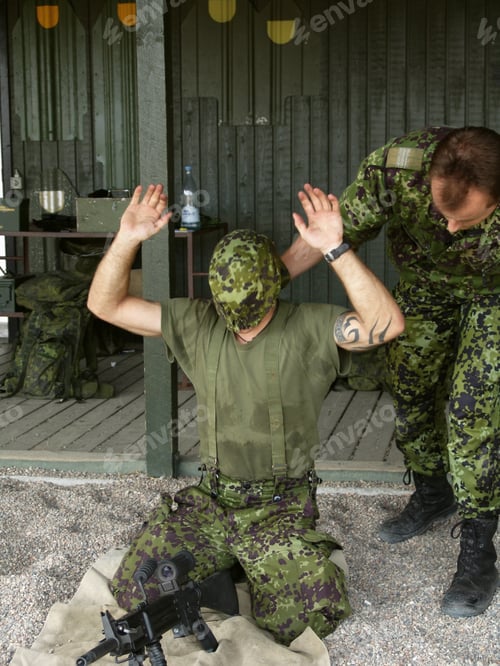 Preview: Done. An experienced soldier raising his hands after assembling his rifle.