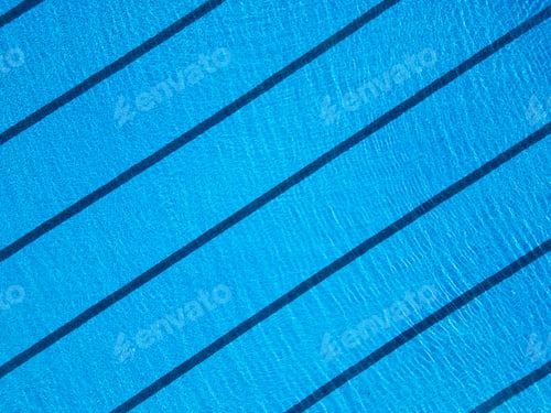 Preview: Aerial view of an empty swimming pool for sports swimming, with clear blue water and lane markings