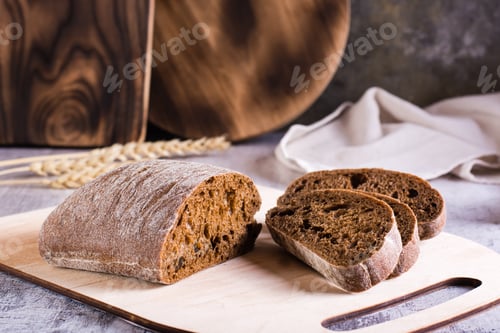 Preview: Sliced rye ciabatta on a cutting board on the table. Homemade baking.