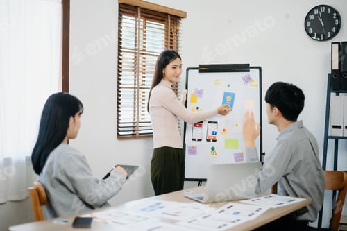 Preview: Close up view of UI developer team brainstorming on their project with laptop, smartphone and