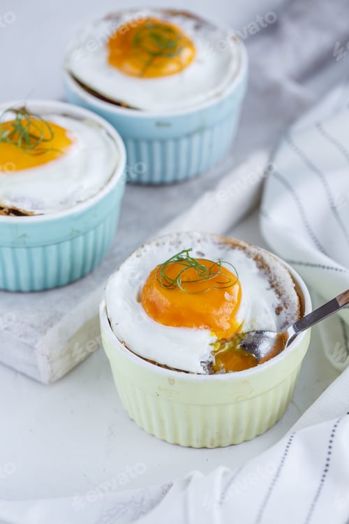 Preview: Three baked egg in ramekins on white background