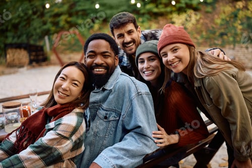 Preview: Happy multiracial group of friends on a patio looking at camera.