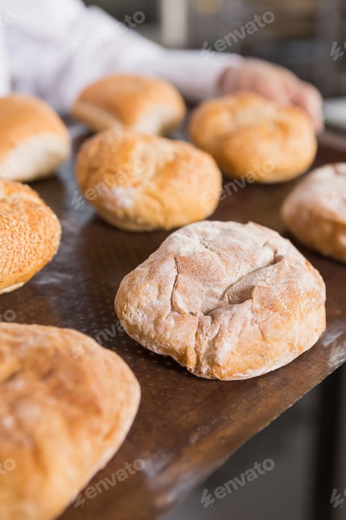 Preview: Close up of baker showing tray of rolls in the kitchen of the bakery