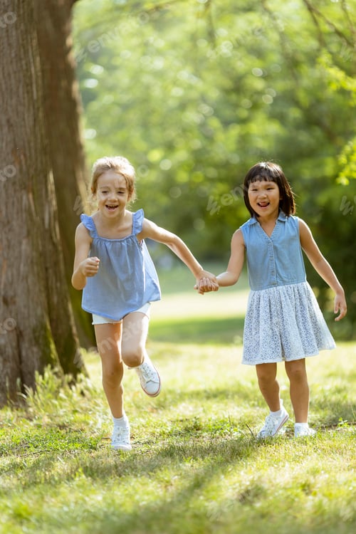Preview: Caucasian and Asian girl running in the park