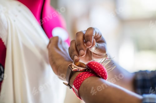 Preview: Close-up of tailor working on dress in studio