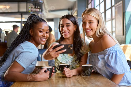 Preview: Group Of Female Friends Meeting Up In Restaurant Or Coffee Shop Posing For Selfie On Mobile Phone