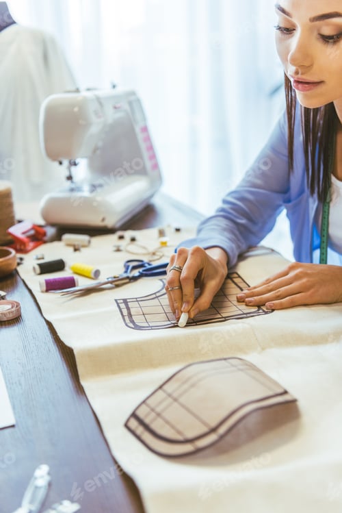 Preview: attractive seamstress marking pattern with piece of chalk