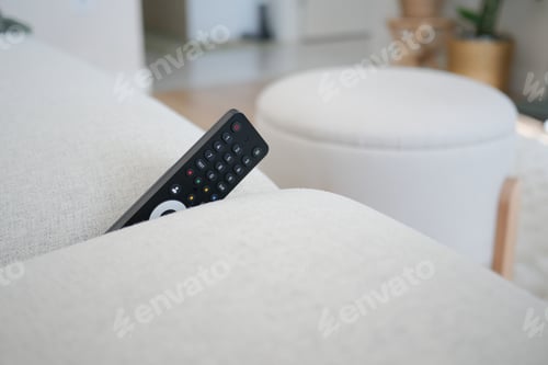 Preview: A remote control slightly peeks out from a couch cushion. lost remote control