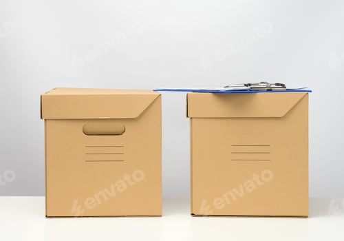 Preview: Two cardboard boxes made of brown corrugated cardboard are on a white table, moving, goods delivery