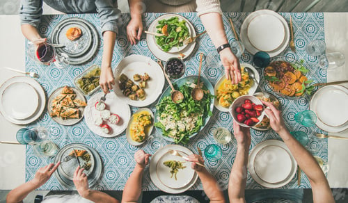 Preview: Flat-lay of hands holding mediterranean starters and various drinks