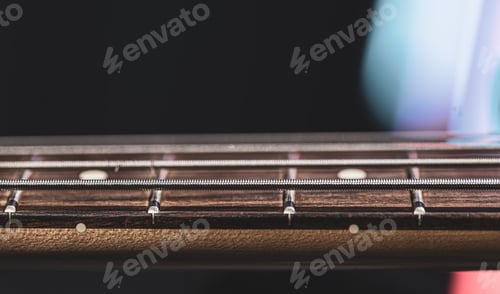 Preview: Close-up of strings on the fretboard of a bass guitar.