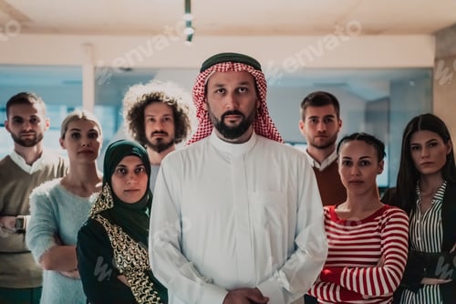 Preview: A diverse group of successful business people in a modern glass office stand together at the top