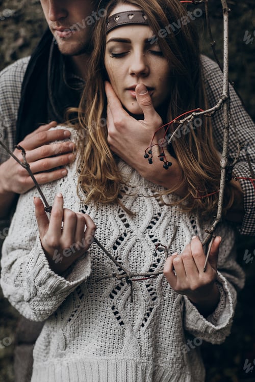Preview: Boho gypsy woman holding branch and man in hat embracing her