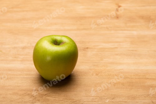 Preview: Close up view of green apple on wooden surface