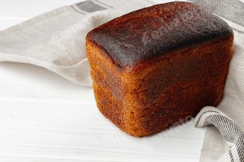 Preview: Loaf of rye bread on white wooden table
