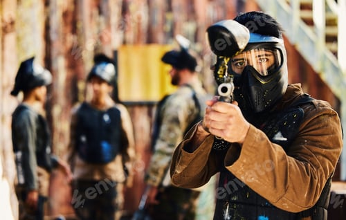 Preview: Paintball, focus or portrait of man with gun in shooting game playing in action battlefield mission