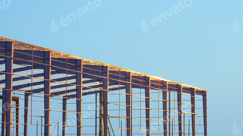 Preview: Factory building framework structure in construction site against blue evening sky background