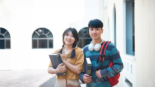 Preview: Smiling students with books on campus