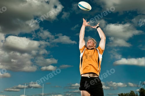 Preview: Rugby player catching the ball under a cloudy sky