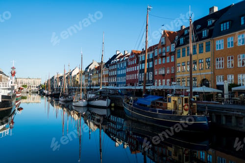 Preview: COPENHAGEN, DENMARK - 06 MAY, 2018: Nyhavn pier with buildings and boats reflected in water,