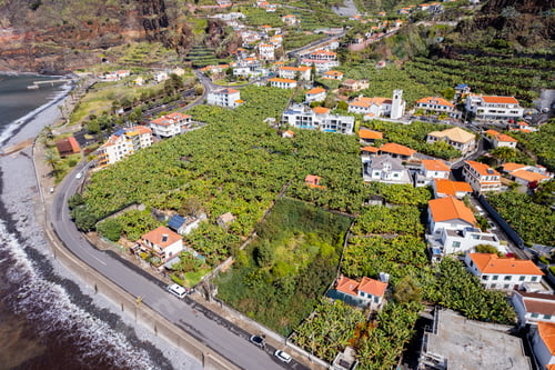Preview: Aerial view of small farming village with banana plantation at Madeira Atlantic Ocean coast