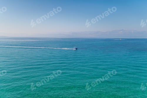 Vorschau: Motorboot segelt auf See vor Horizont unter blauem Himmel