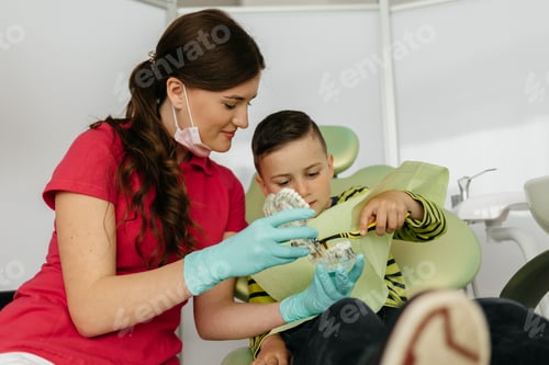 Preview: A young dentist shows a child how to brush their teeth