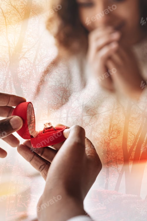 Preview: Saying Yes. Close Up Of Red Heart Shaped Box With Wedding Ring In Hands Of A Man Proposing To His
