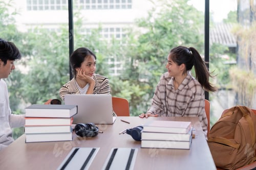 Preview: Group of Student Studying Together in a Modern Library with Laptops and Books