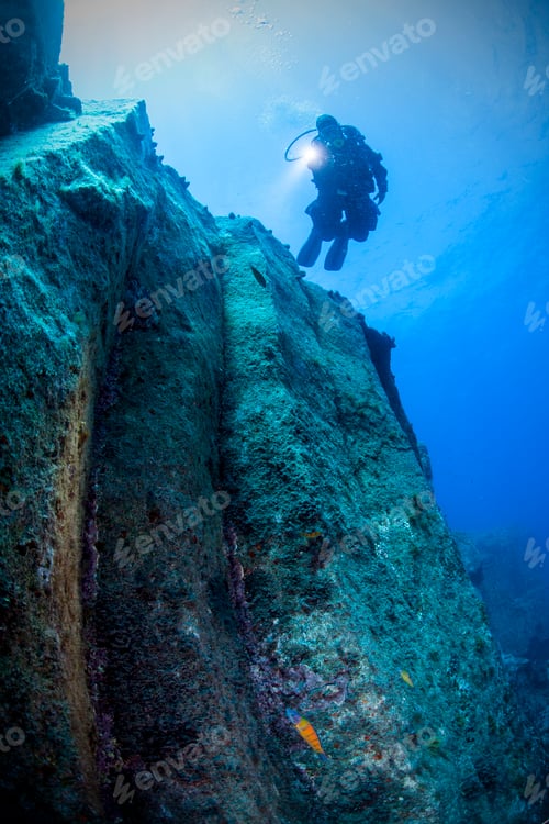 Preview: A Scuba Diver Uses a Light to Illuminate Steep Underwater Wall