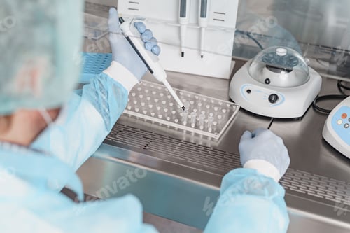 Preview: Back view of scientist is using micropipette for biochemical test analysis in medical laboratory