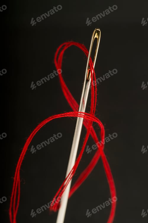 Preview: Red thread pulled through needle's eye