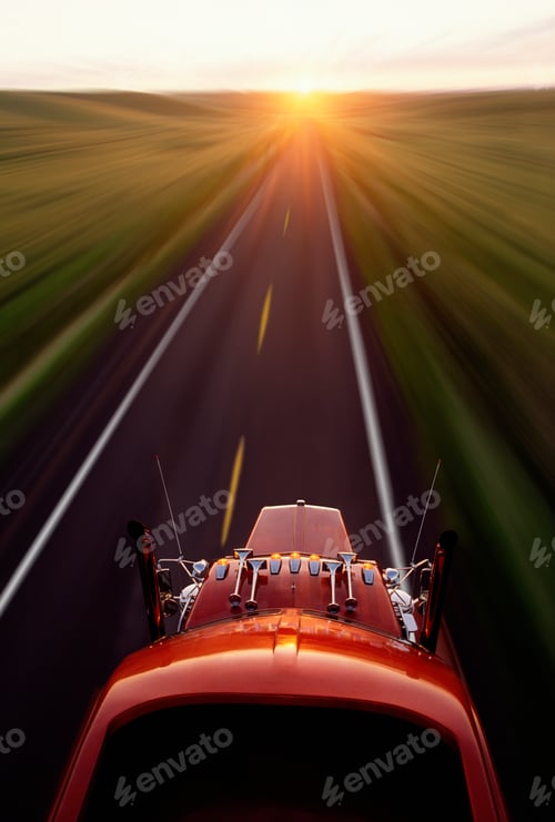 Preview: Looking down on a Kenworth W900 Class 8 truck moving down the road at sunrise on highway 129 in