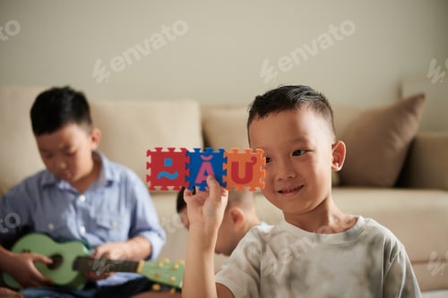 Preview: Vietnamese Boy Playing with Alphabet Puzzle