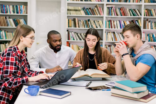 Preview: Front view of four good-looking modern smart mixed race students which are sitting in the reading