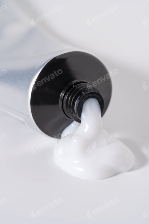 Preview: White cosmetic cream or hair product dispensing from a tube.