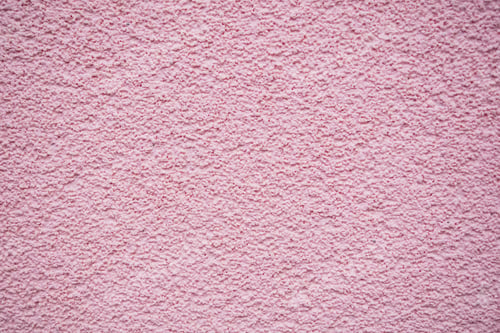 Preview: Closeup shot of a pink, grainy, and textured wall