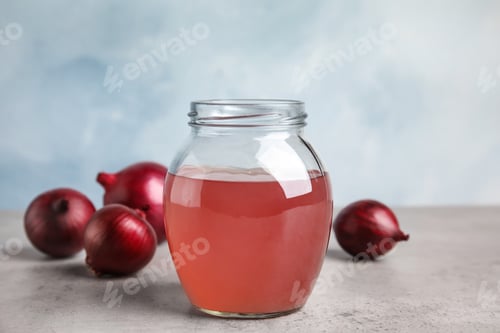 Preview: Glass jar of onion syrup and fresh vegetable on table