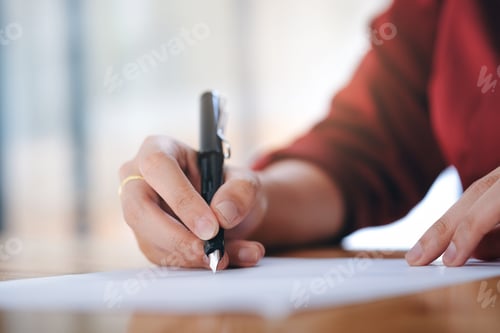 Preview: Woman's hand holding pen writing on blank white paper.