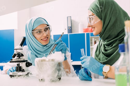 Preview: smiling female muslim scientists experimenting with microscope and dry ice in chemical laboratory