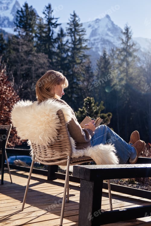 Preview: Woman journaling New Year intentions on mountain sunny terrace