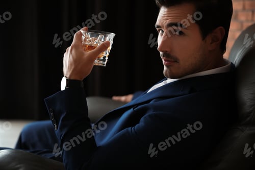 Preview: Young man with glass of whiskey indoors