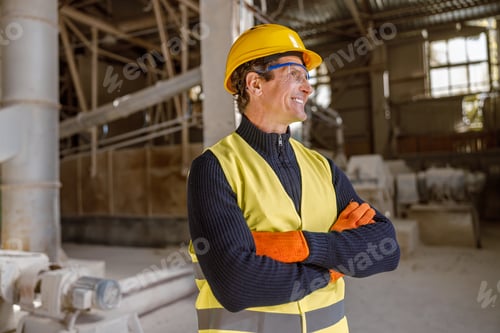 Preview: Joyful male worker standing at industrial site