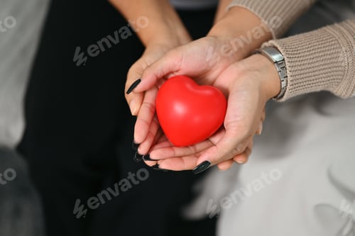 Preview: Women hands holding red heart. Health care, insurance and world heart day concept