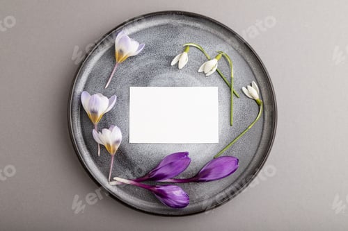 Preview: White paper invitation card, mockup with crocus and galanthus flowers on ceramic plate and gray