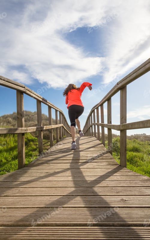 Preview: Back view of girl running in a wood boardwalk